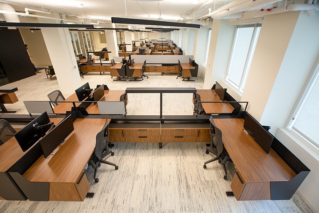 Clusters of workstations with storage and screens along the spine