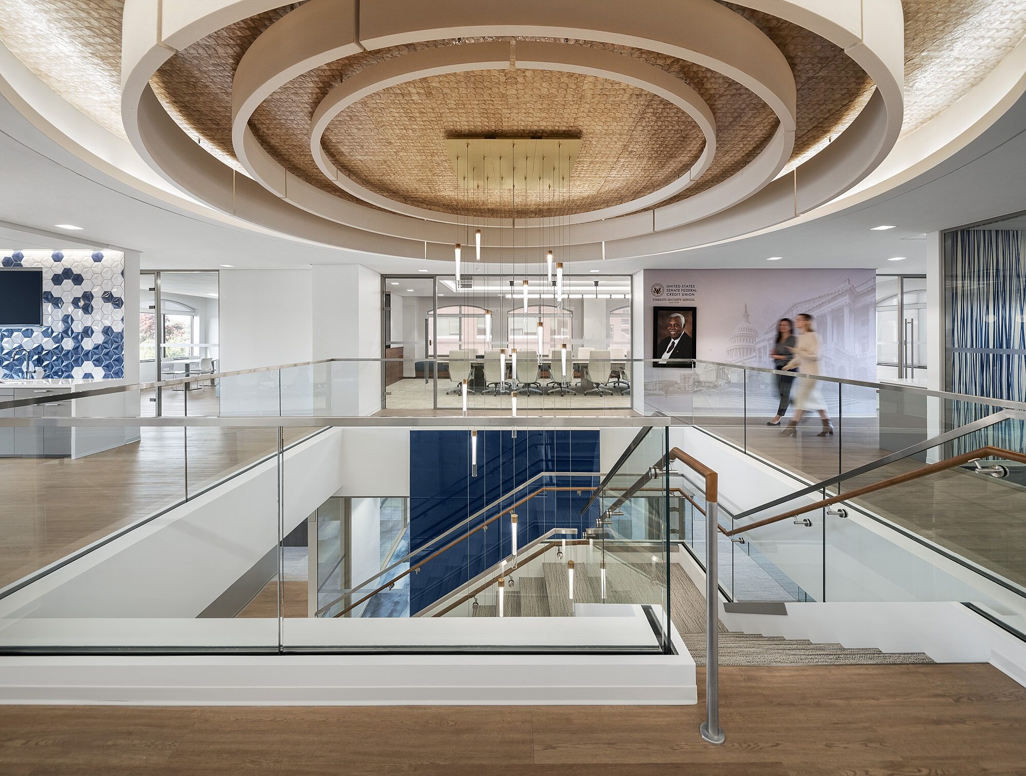 A view from the top of a stairwell with a sculptural ceiling detail above