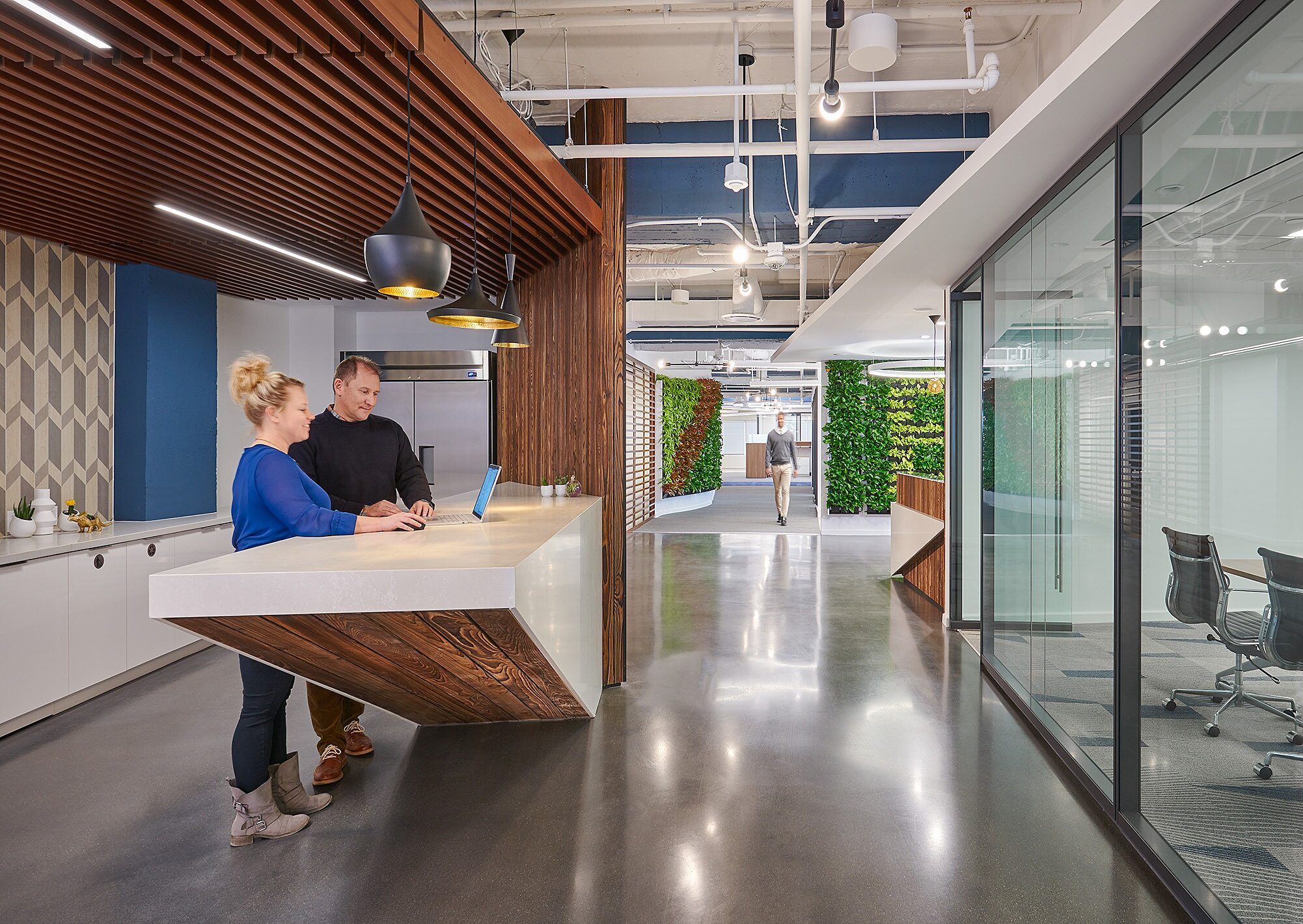 A kitchen in an office with people standing at a counter