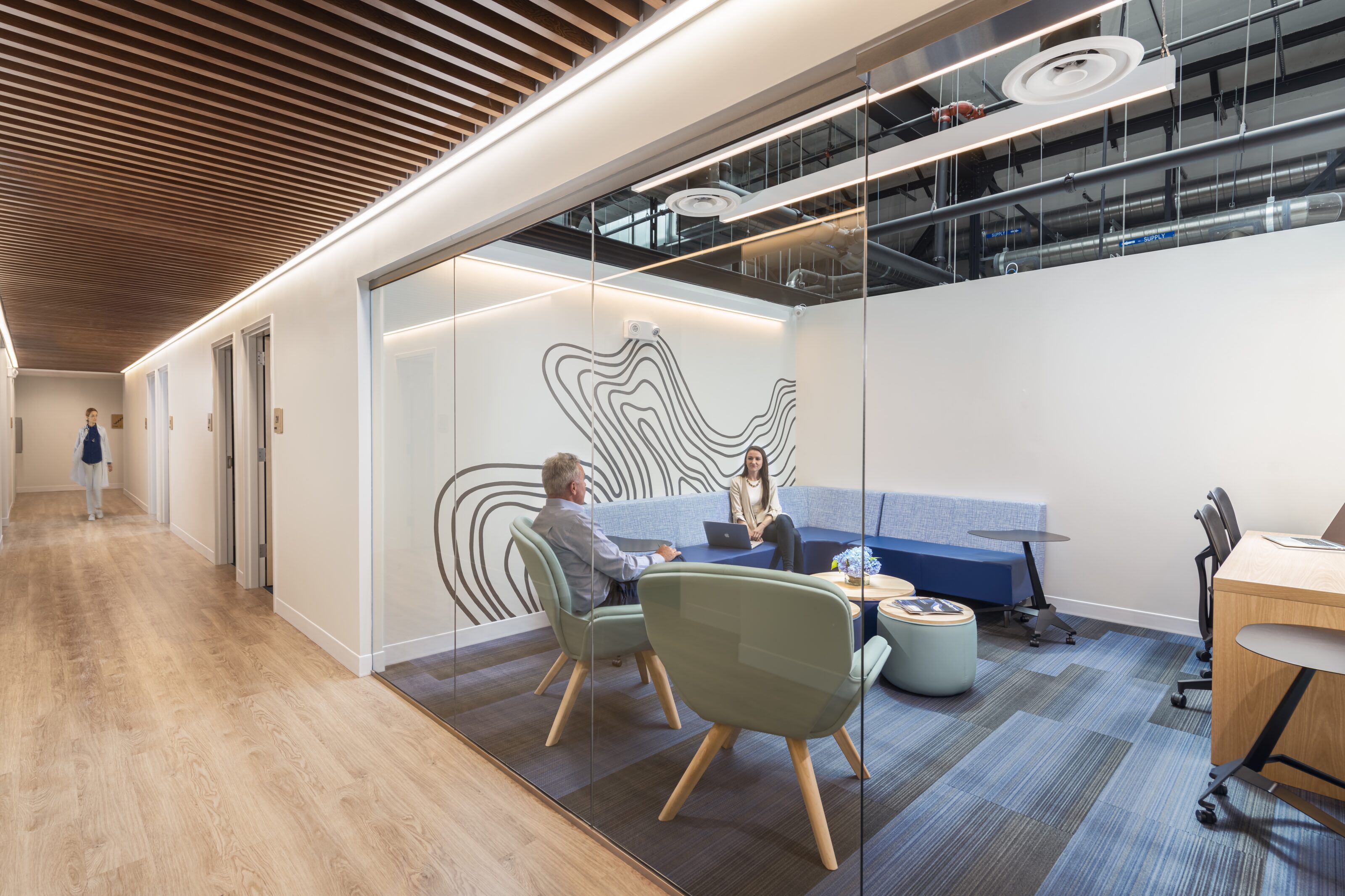 An office with people seated in lounge furniture inside it.