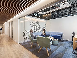 An office with people seated in lounge furniture inside it.