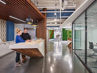 A kitchen in an office with people standing at a counter