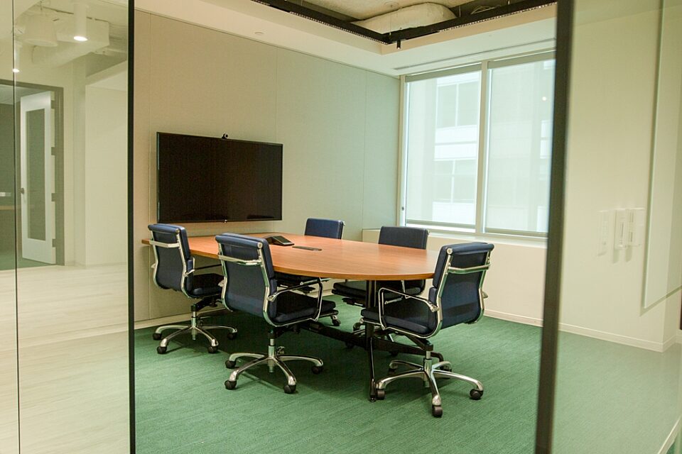 A conference room with D-shaped table and chairs